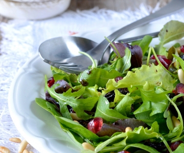 A salad with fresh greens and pomegranates