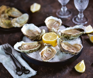A dish of oysters served with a lemon