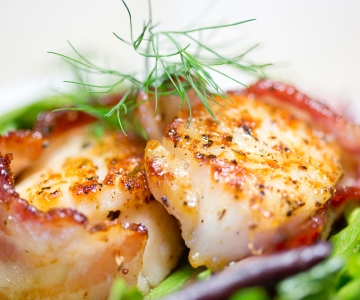 Bacon wrapped scallops served with fresh herbs