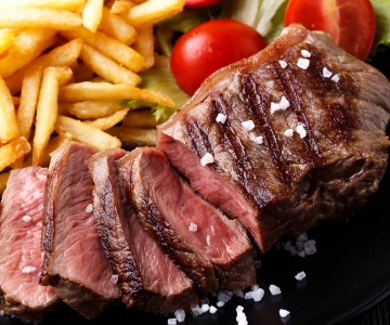 A steak cut up served with fries