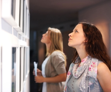 Two women looking at art pieces.