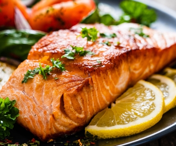 A salmon dinner served with fresh herbs and lemon slices